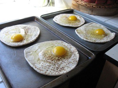 Cracked eggs on mini pizzas
